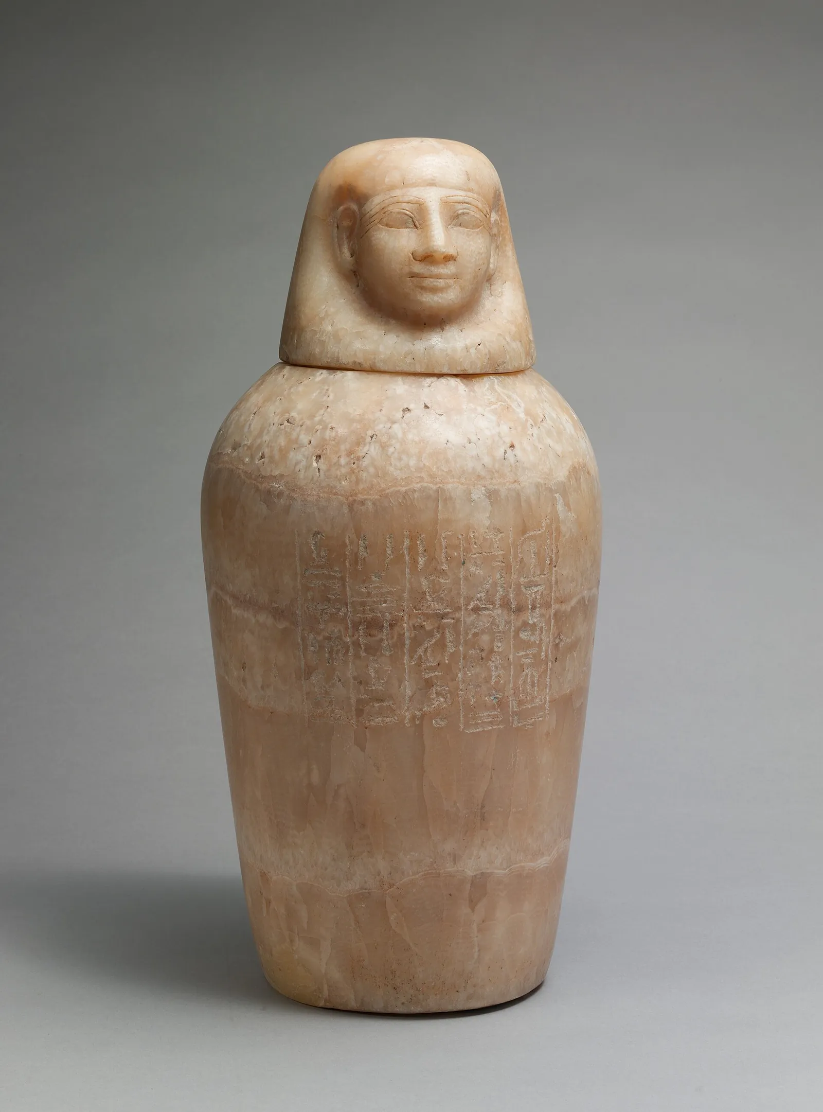 An Egyptian canopic jar with a human-headed lid